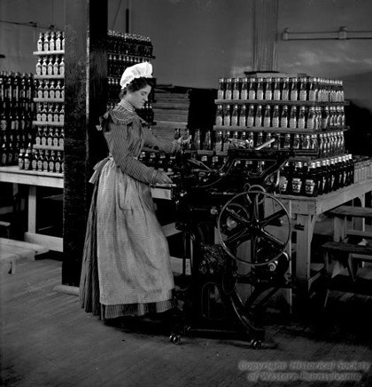 Photograph of girl with labeling machine, c. 1901